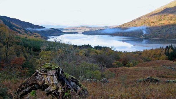 Smoke from a chimney rises vertically on the far shore of Loch Creran