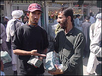 دو افغان که پول افغانی در دست دارند