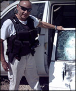 Kev inspects the damage to a car