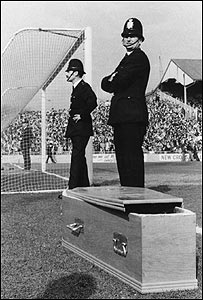 Police stand by a coffin at Millwall's Den, 1978