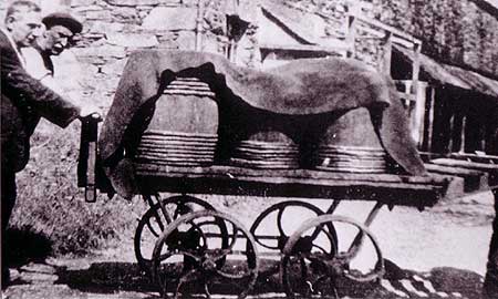 men pushing barrels covered in heavy leather