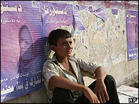 Irácký mladík pod plakáty, které vyzývají k účasti v referendu o ústavě