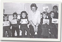 Mrs Marian Jones gyda disgyblion Ysgol Llanllechid a'r llyfrau