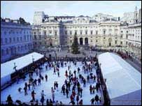 Crianças e adultos patinam no rinque de gelo no pátio interno da Somerset House