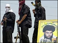 پوستری از مقتدی صدر در کنار حاميان مسلح وی