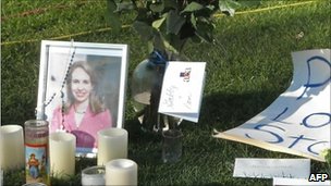 Photographs of US Congresswoman Gabrielle Giffords are set amid flowers and candles outside the University Medical Center in Tucson, Arizona