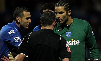 Un árbitro rodeado de varios jugadores en Inglaterra