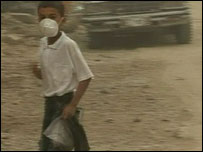 Menino se protege de tempestade de areia com máscara