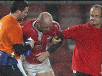 Gareth Thomas yn derbyn cymorth wrth afael y maes