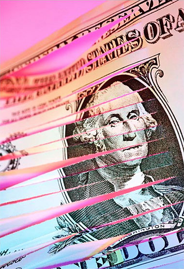 Billete de dólar estadounidense rajado en tiritas.