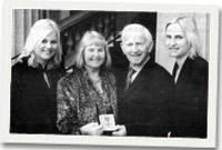 John Glyn a Myra Williams ar ôl iddo dderbyn ei MBE, gyda'i ddwy ferch