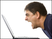 A man shouting at a laptop