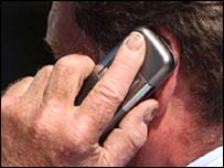 ایک شخص لندن میں موبائل فون استعمال کرتے ہوئے