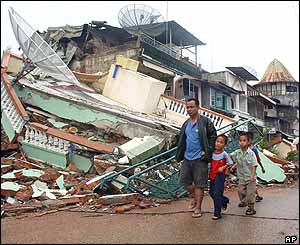 Tři chlapci kráčející se svým otcem ulicí poničenou zemětřesením, Gunungsitoli na ostrově Nias, Indonésie (30/03/2005)
