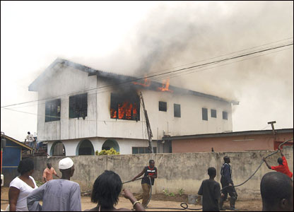 Firefighters frantically try to manoeuvre a hose into position as a fire takes hold in a residential building in Madina in the suburbs of the capital, Accra