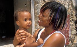 Beverley cradles baby - pic from Christian Aid/ Harriet Logan/ Network