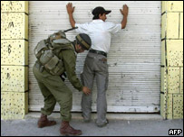 Soldado israelense revista palestino em Hebron