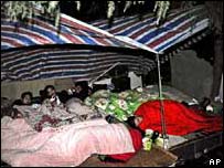 Pessoas em barracas na rua à noite