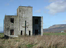 The control tower still survives but is only a shell with just two signs on two doors inside to hint at its original purpose.