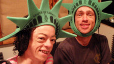 Mat Frazer and Liz Carr wearing statue of liberty foam head-pieces