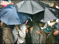 Yağmur altında yardım bekleyen depremzedeler