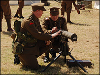 Two soldiers demonstrate a vintage gun