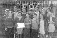 Aelodau o'r Cwmni Teledu gyda'r tlws a'r dystysgrif am Y Ffilm Orau gyda blant Ysgol Gynradd.