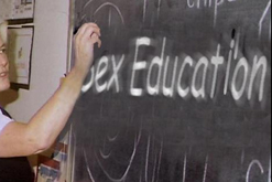 Image: Teacher writing 'sex education' on a blackboard