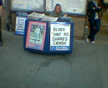 Newspaper sandwich board showing headline 'Blind panic as shares crash'
