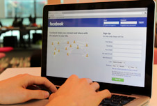 Someone blogging on Facebook using a mobile phone