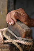 Cuban person's hand resting on a post, which is tied with ropes. © M Doubrava/iStockphoto