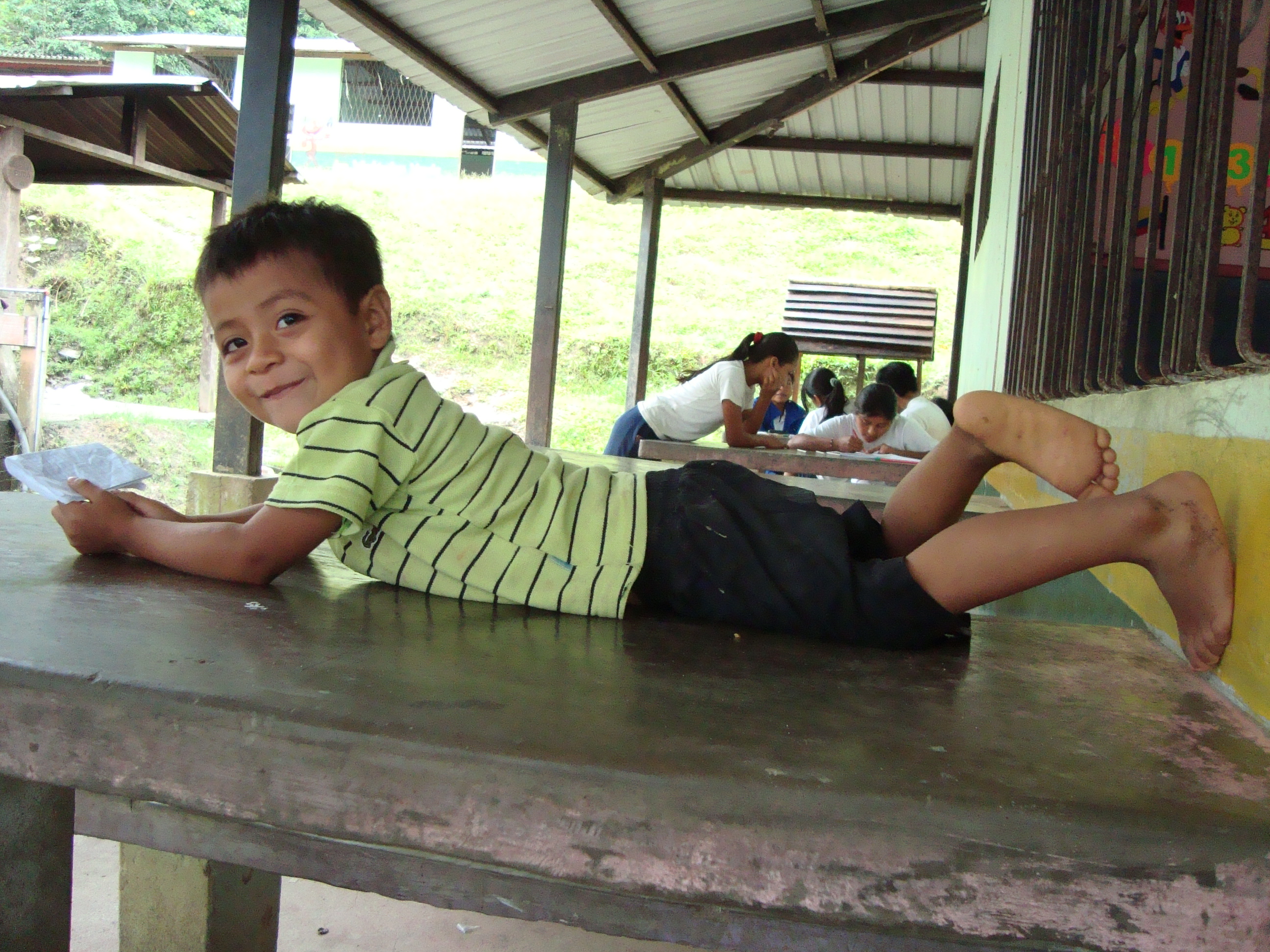 Young boy lying on a table on his tummy relaxing during break time at school