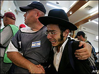 Izraelští vojáci odnášejí osadníka