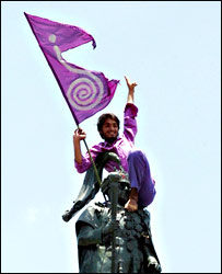 राजा की मूर्ति पर से राजशाही का ध्वज हटाते प्रदर्शनकारी