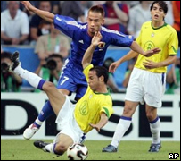 Assistido por Kaká, ao fundo, Leo disputa a bola com o jagador do Japão Hidetoshi Nakata