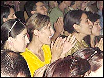 तालियाँ बजाते कुछ दर्शक