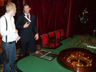 Rob talks to one of the casino staff in front of the roulette table