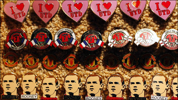 Badges depicting Manchester United striker Wayne Rooney are sold on a street stall before their Champions League match against Bursaspor at Old Trafford