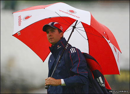 Michael Vaughan walks under an umbrella as rain delays the first day of the Test Match against New Zealand