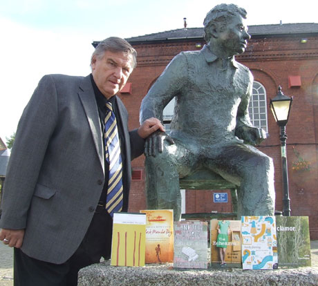 Professor Peter Stead, prize founder and judge, with the shortlisted books taken at the statue of Dylan Thomas in Swansea
