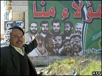 Palestinian arătând către un afiş electoral Hamas