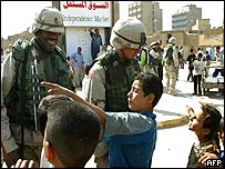 Criança iraquiana conversa com soldados americanos