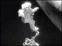 اسفان رابينسون زير شکم شاتل درحال بيرون کشيدن قطعات زائد