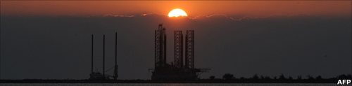 The sun sets over an oil platform waiting to be towed out into the Gulf of Mexico at Port Fourchon in Louisiana, on 4 May 2010
