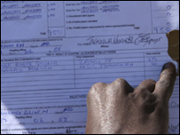 Một người đàn ông xem kết quả bỏ phiếu ở một địa điểm bầu cử