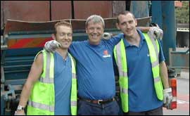 Three bin men next to a bin lorry