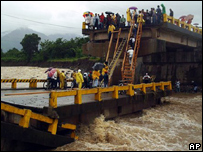 Moradores tentam atravessar uma ponte que atravessava o rio Moga, em Saba, no norte de Honduras