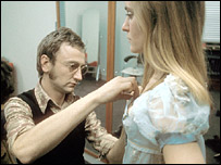 Man adjusting woman's costume