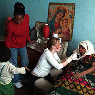 Vicky helps to look after Abel's mum. Fantaye, her carer stands behind her.