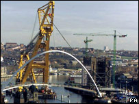 A crane moving a bridge up the River Tyne